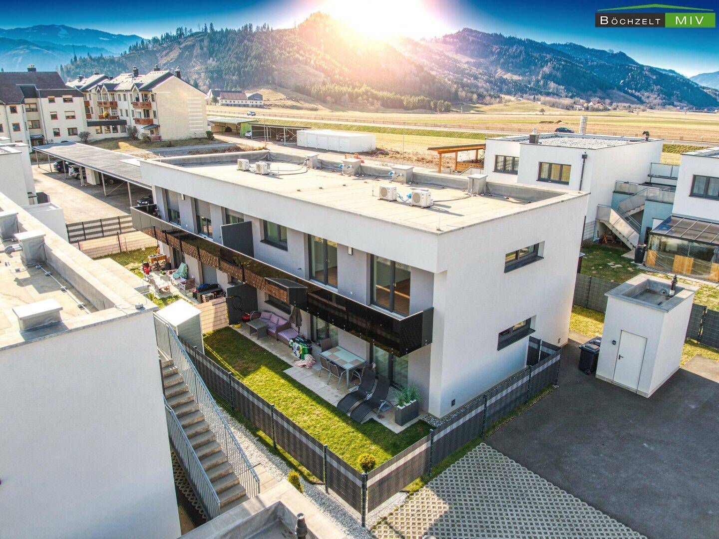 Moderne Wohngebäude mit privaten Gärten, Terrassen und Blick auf die umliegende Landschaft.
