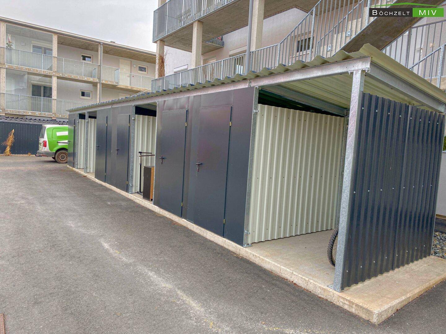 Reihe von abschließbaren Abstellräumen oder Fahrradboxen im Außenbereich.