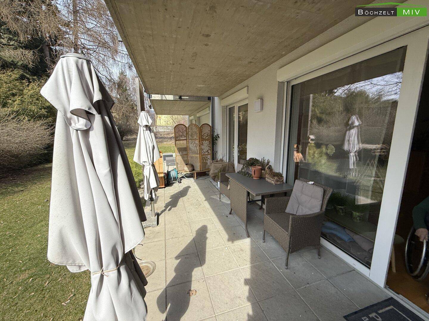 Sonnige überdachte Terrasse mit Gartenmöbeln und direktem Zugang zum Wohnbereich.