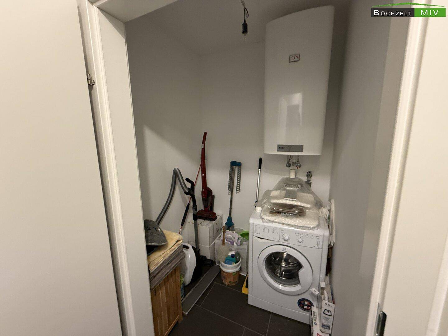 Praktischer Hauswirtschaftsraum mit Waschmaschine und Warmwasserboiler für den täglichen Bedarf.