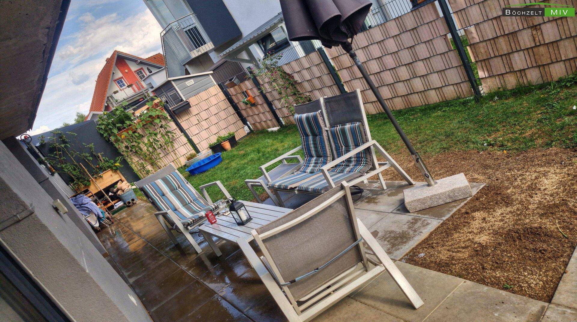 Gemütliche Terrasse mit Gartenmöbeln und Sonnenschirm, ideal für entspannte Stunden.
