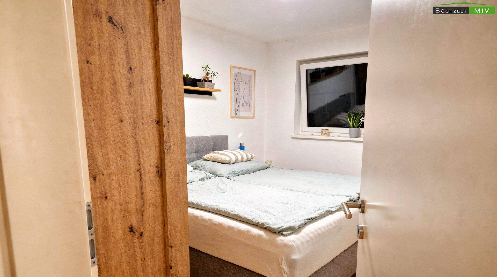 Ruhiges Schlafzimmer mit Doppelbett, Holzboden und Fenster für natürliches Licht.