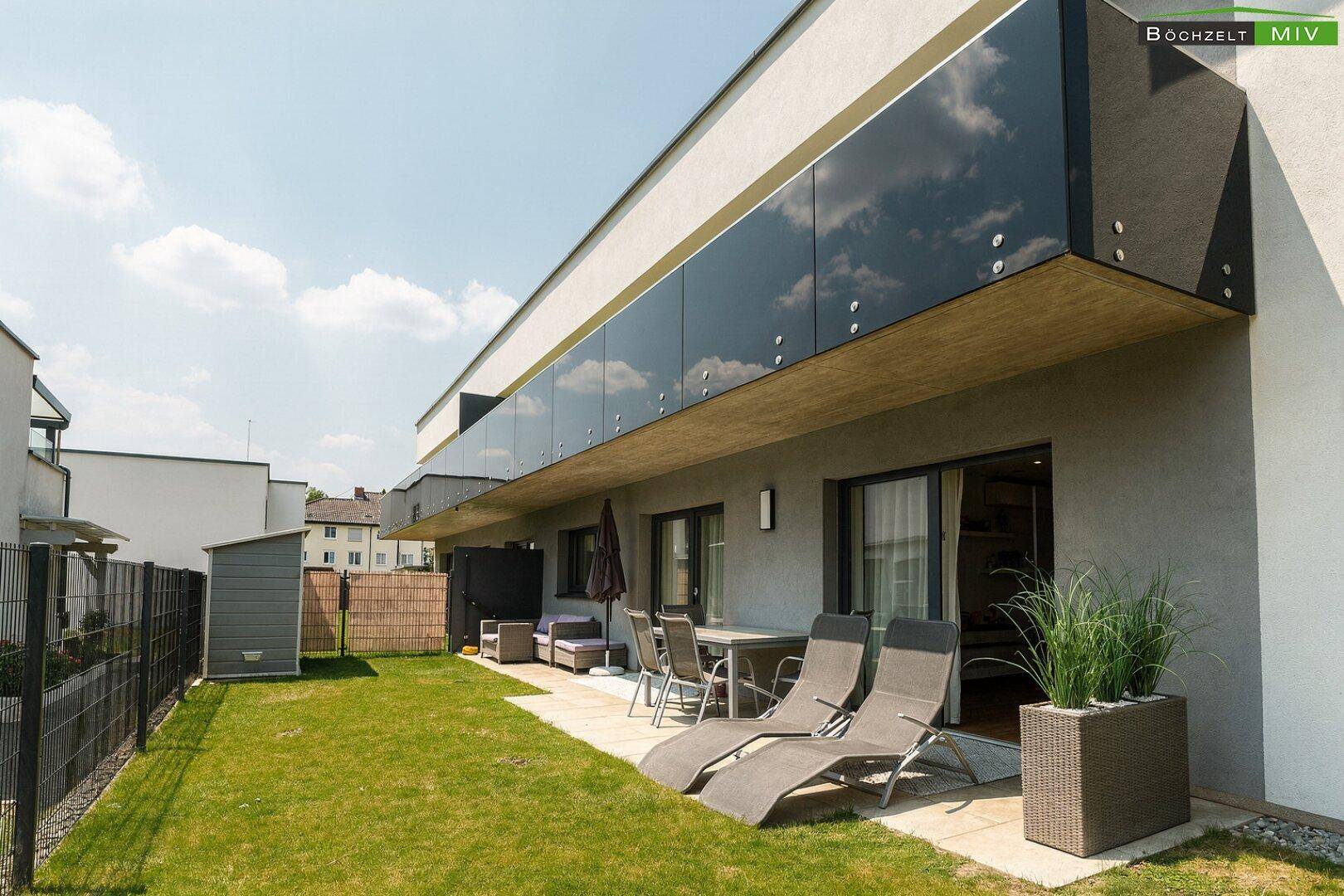 Sonniger Privatgarten mit Terrasse, Gartenmöbeln und Liegestühlen für entspannte Stunden.