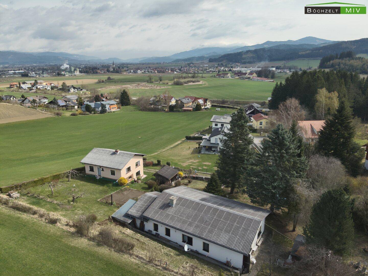 Weitwinkel-Luftaufnahme des Anwesens mit Blick auf die umliegende ländliche Siedlung und die Berglandschaft.