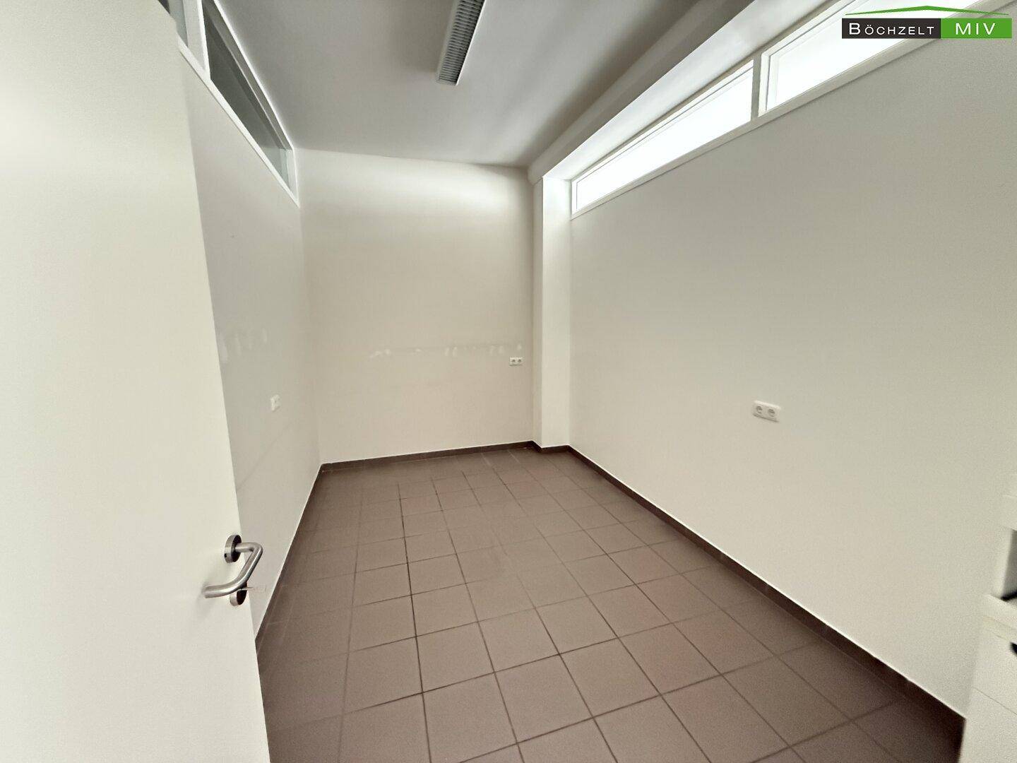 Heller Raum mit Fliesenboden und weißen Wänden, geeignet als Büro oder Lagerfläche.