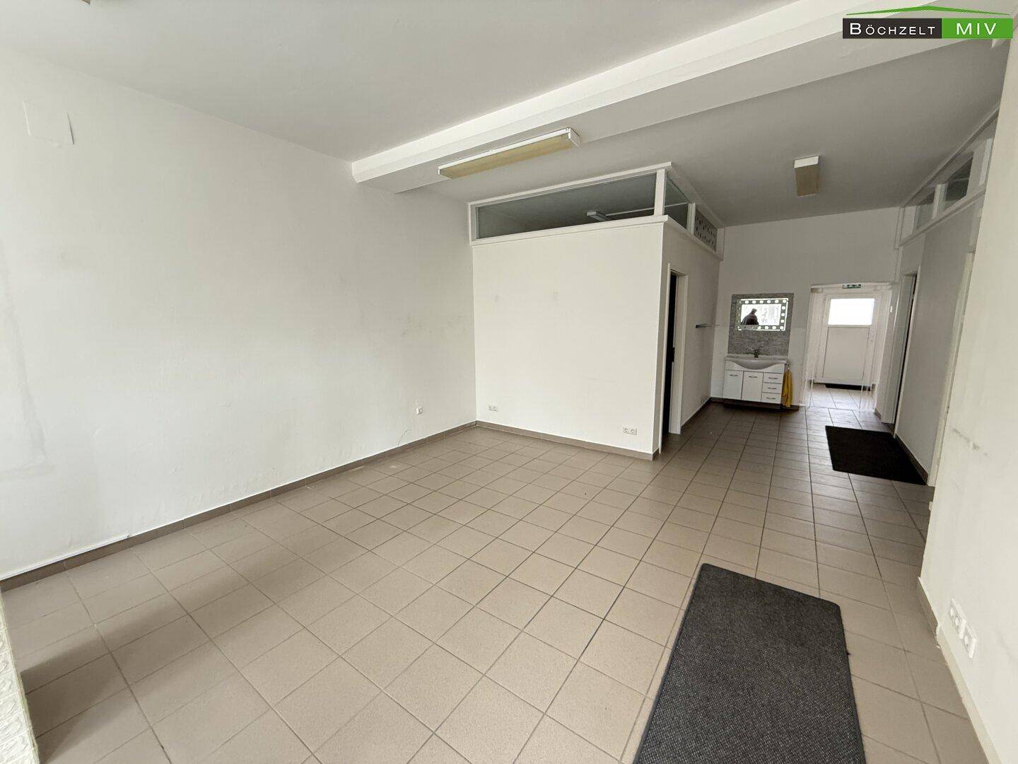 Geräumiger Verkaufsraum mit Fliesenboden, weißen Wänden und einem Blick in den hinteren Bereich.
