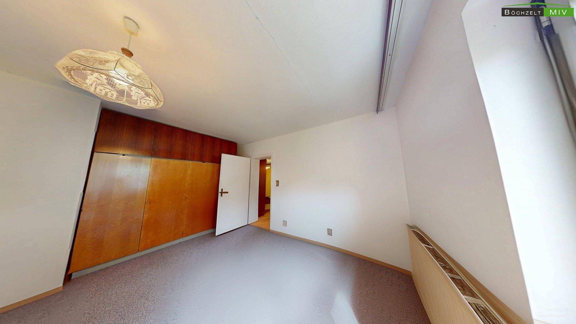 Geräumiges Schlafzimmer mit Teppichboden und großem Einbauschrank, der viel Stauraum bietet.