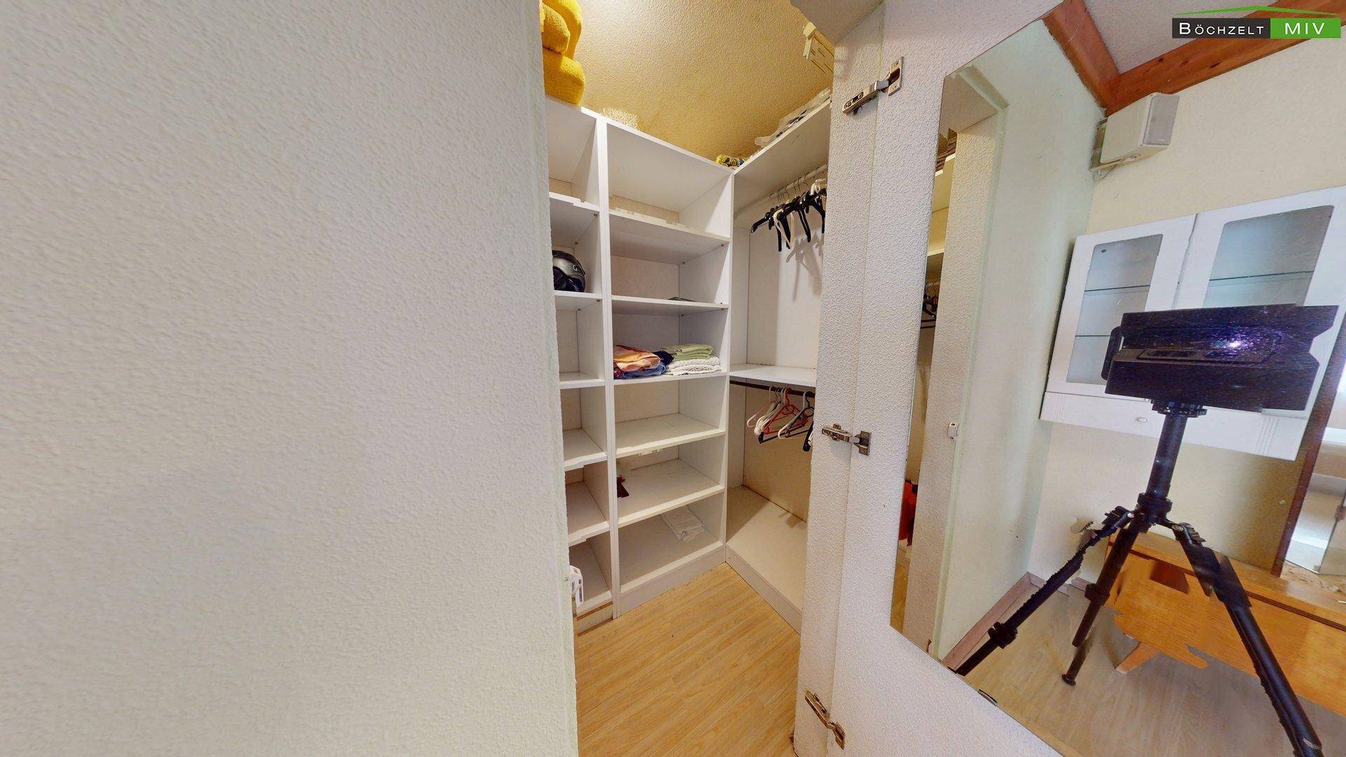 Praktischer begehbarer Kleiderschrank mit Regalen und Kleiderstangen, der viel Stauraum bietet.