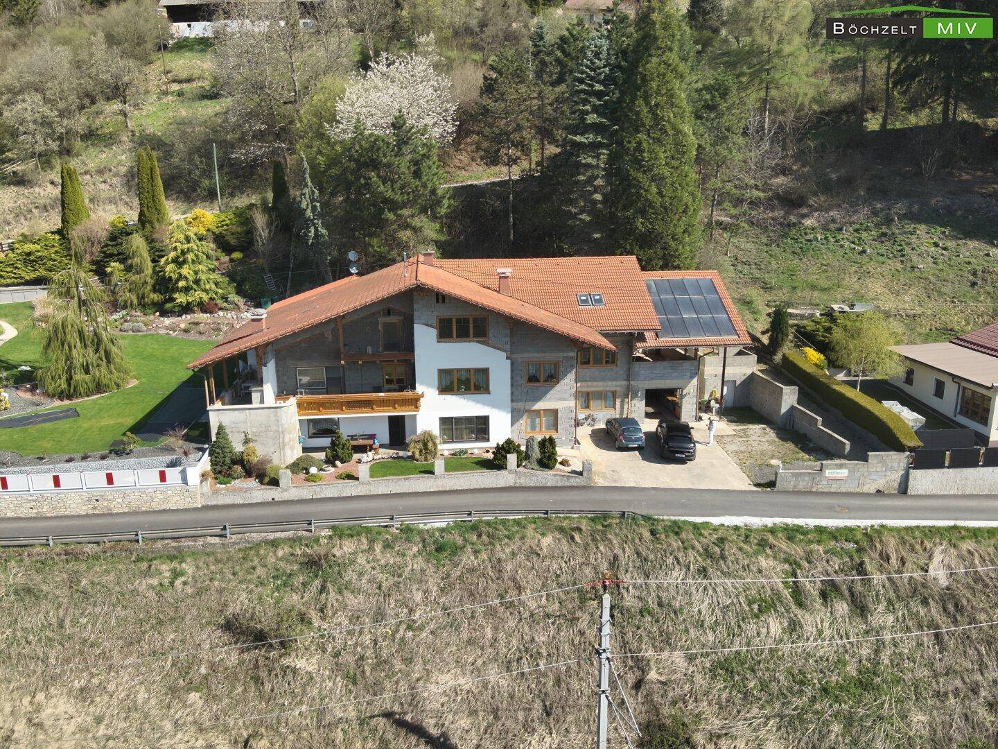 Ansicht des Hauses von vorne mit Solaranlage auf dem Dach und gepflegter Zufahrt.