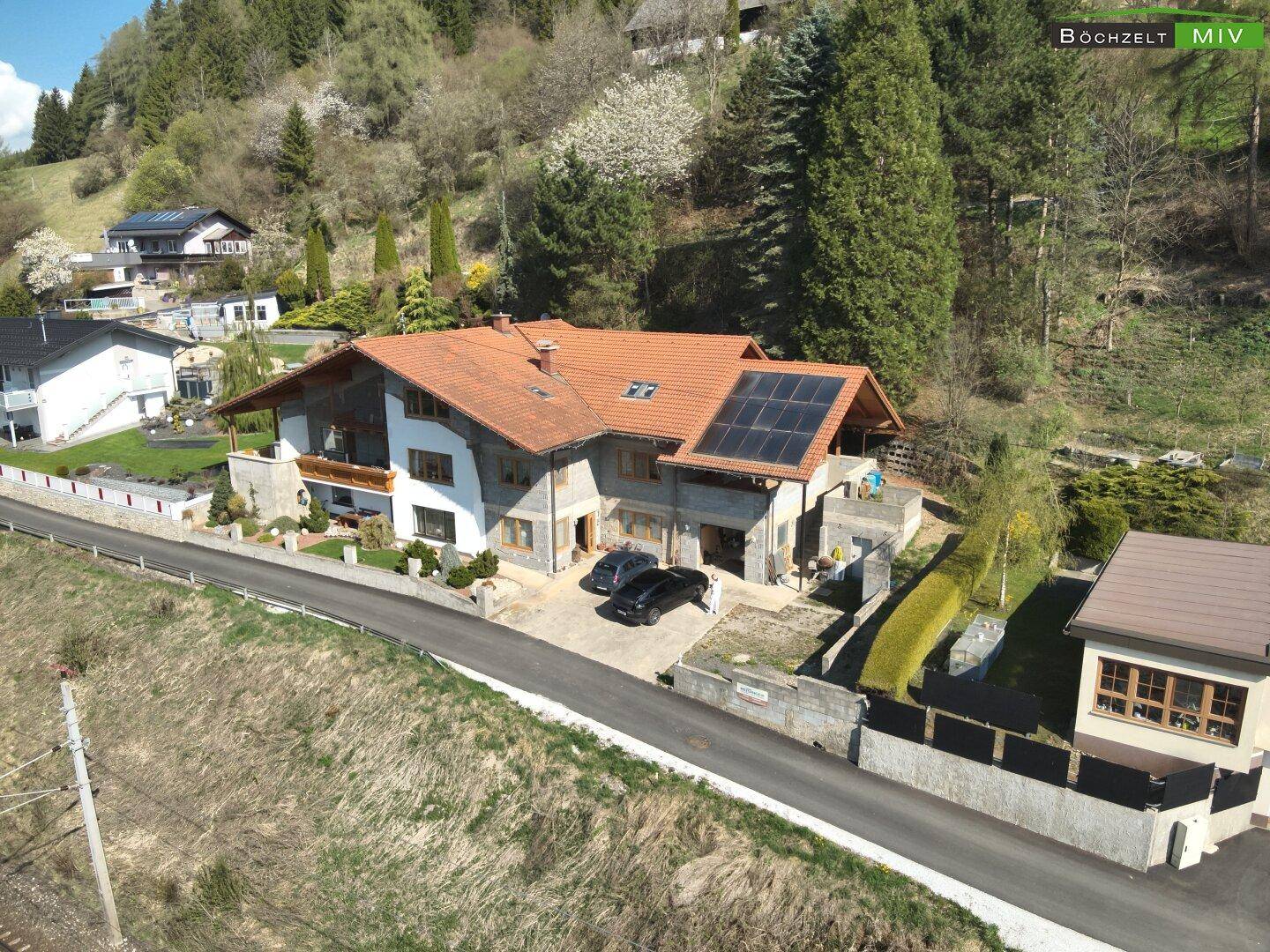 Ansicht des Hauses von vorne mit Solaranlage auf dem Dach und gepflegter Zufahrt.