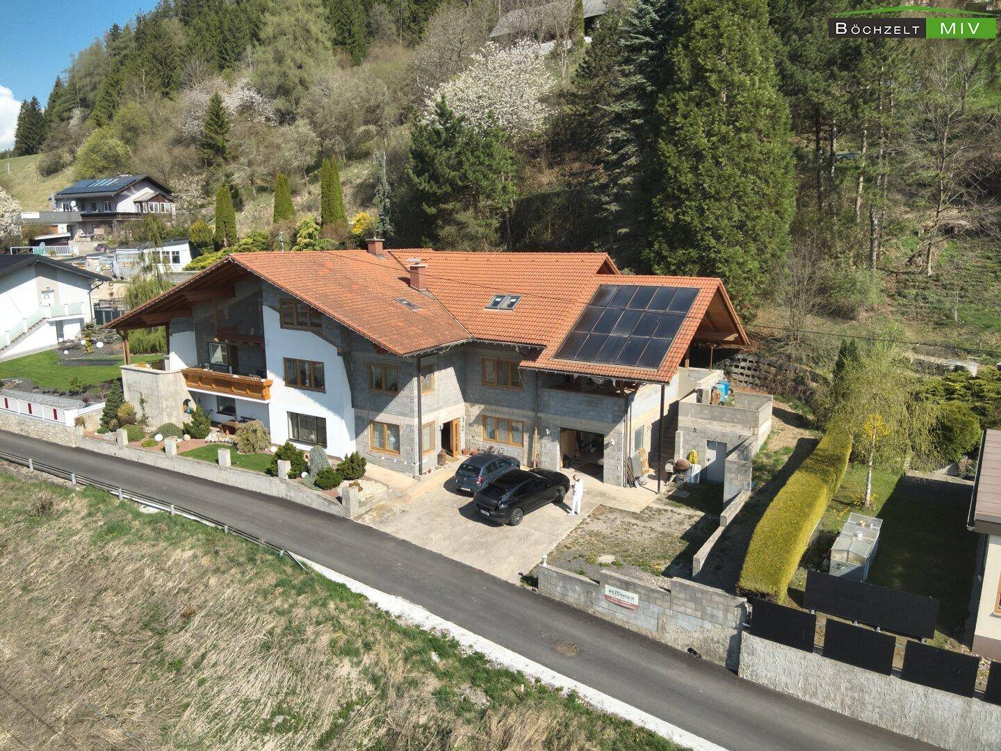 Ansicht des Hauses von vorne mit Solaranlage auf dem Dach und gepflegter Zufahrt.