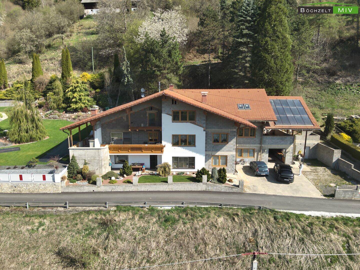 Ansicht des Hauses von vorne mit Solaranlage auf dem Dach und gepflegter Zufahrt.