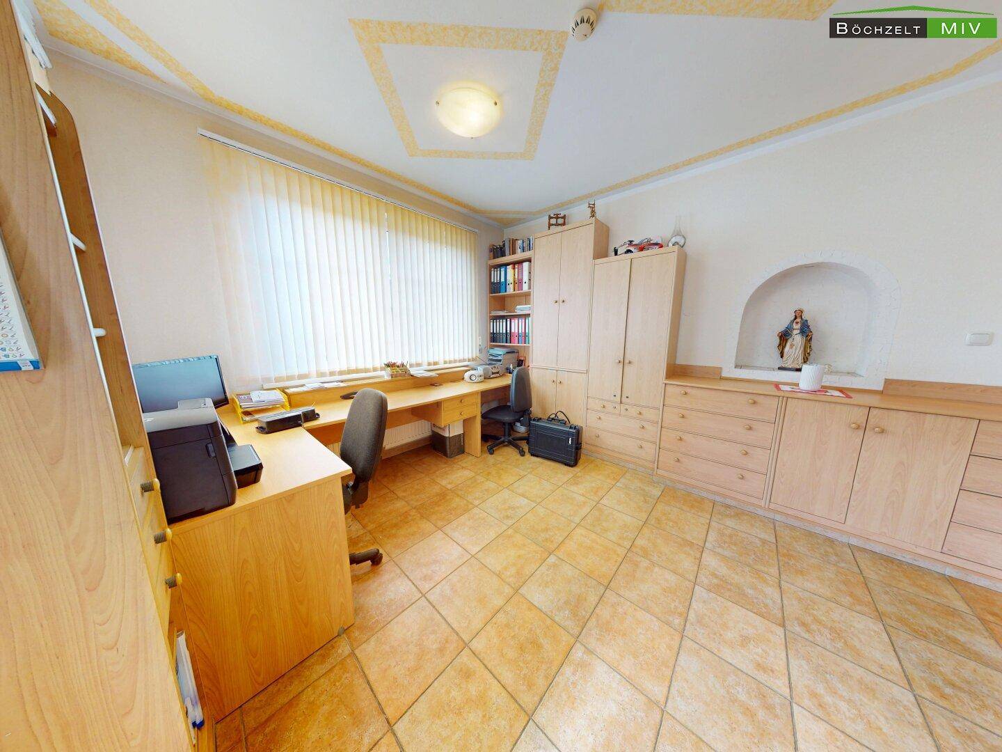 Helles Büro mit Holzmöbeln, gefliestem Boden und einem dekorativen Wandnischenbereich.