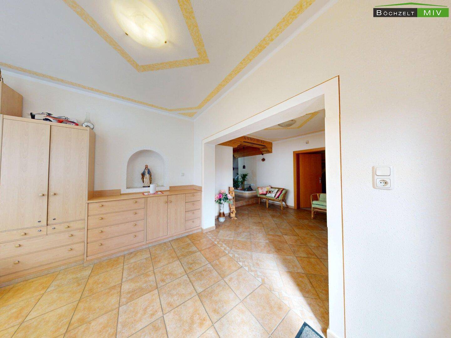 Geräumiger Flur mit Holzschränken, gefliestem Boden und Zugang zu weiteren Räumen.