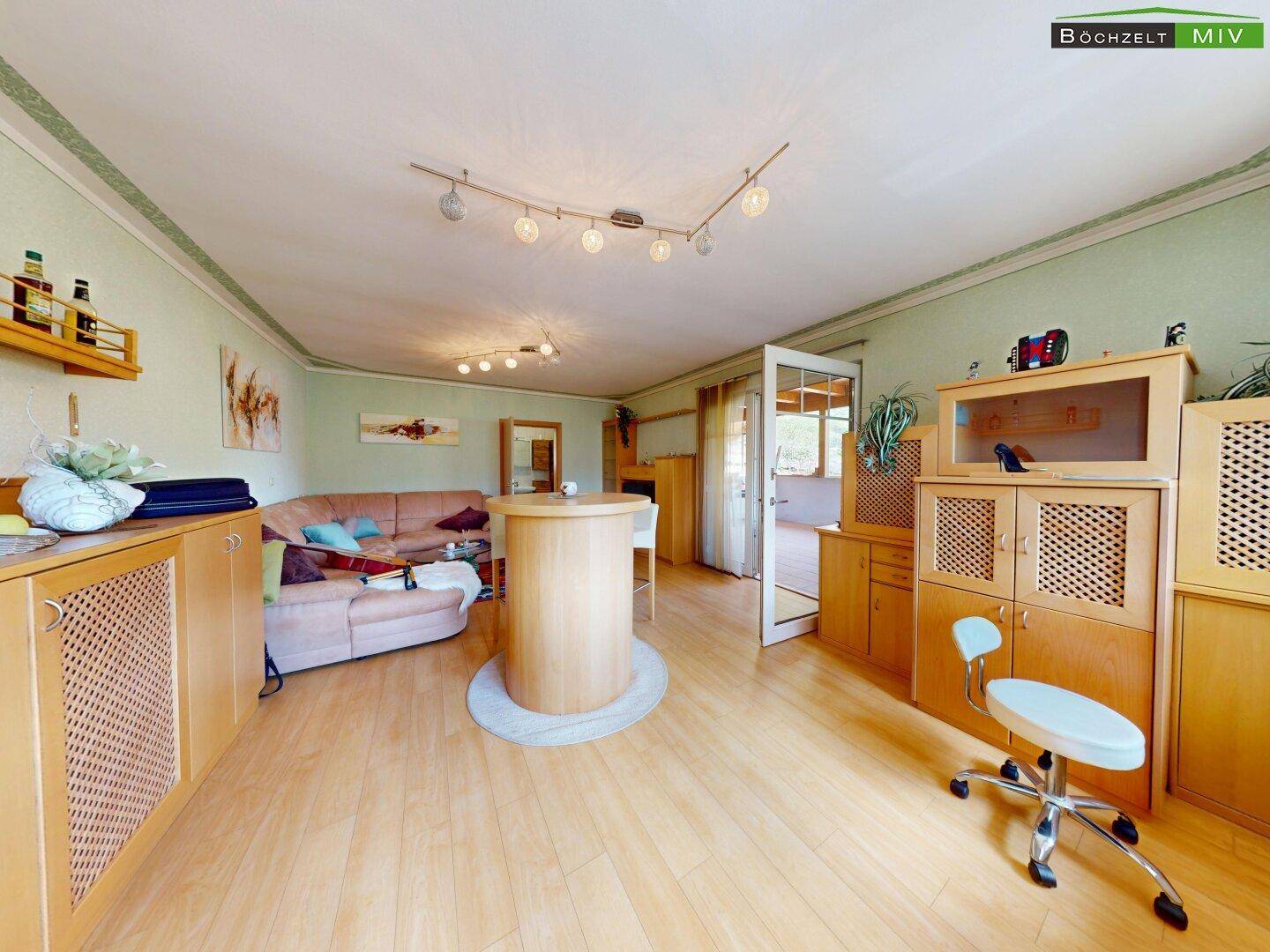 Wohnzimmer mit Barbereich, bequemer Couch und hellgrünen Wänden.