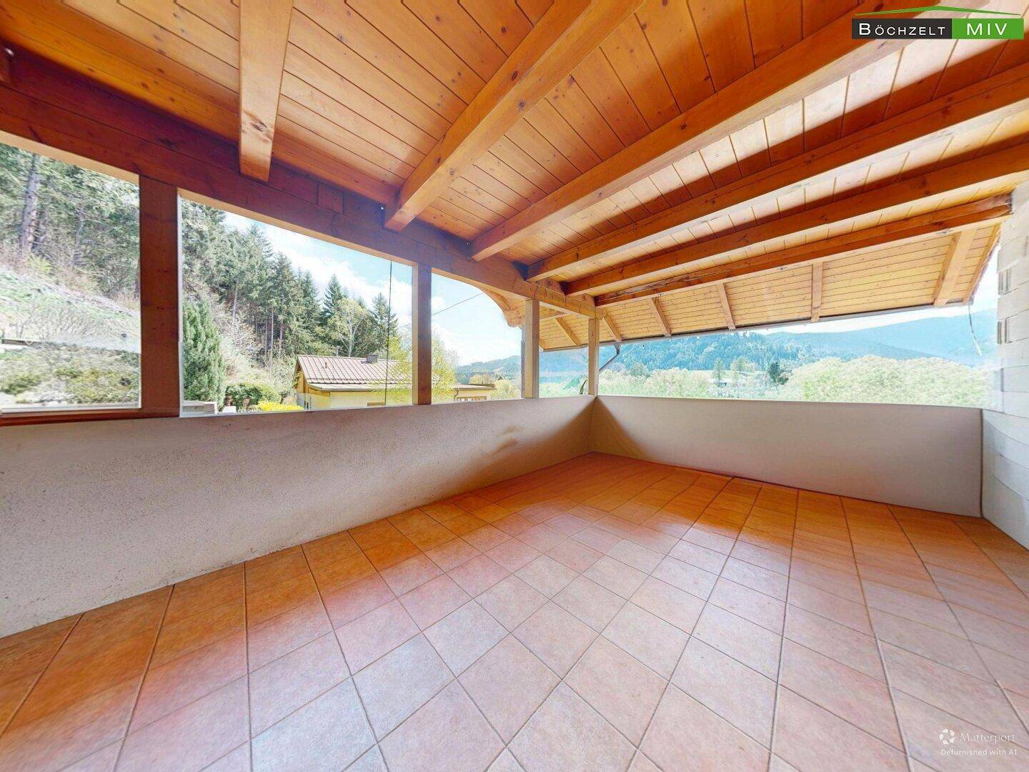 Geräumige überdachte Terrasse mit weitem Blick auf die umliegende Landschaft.