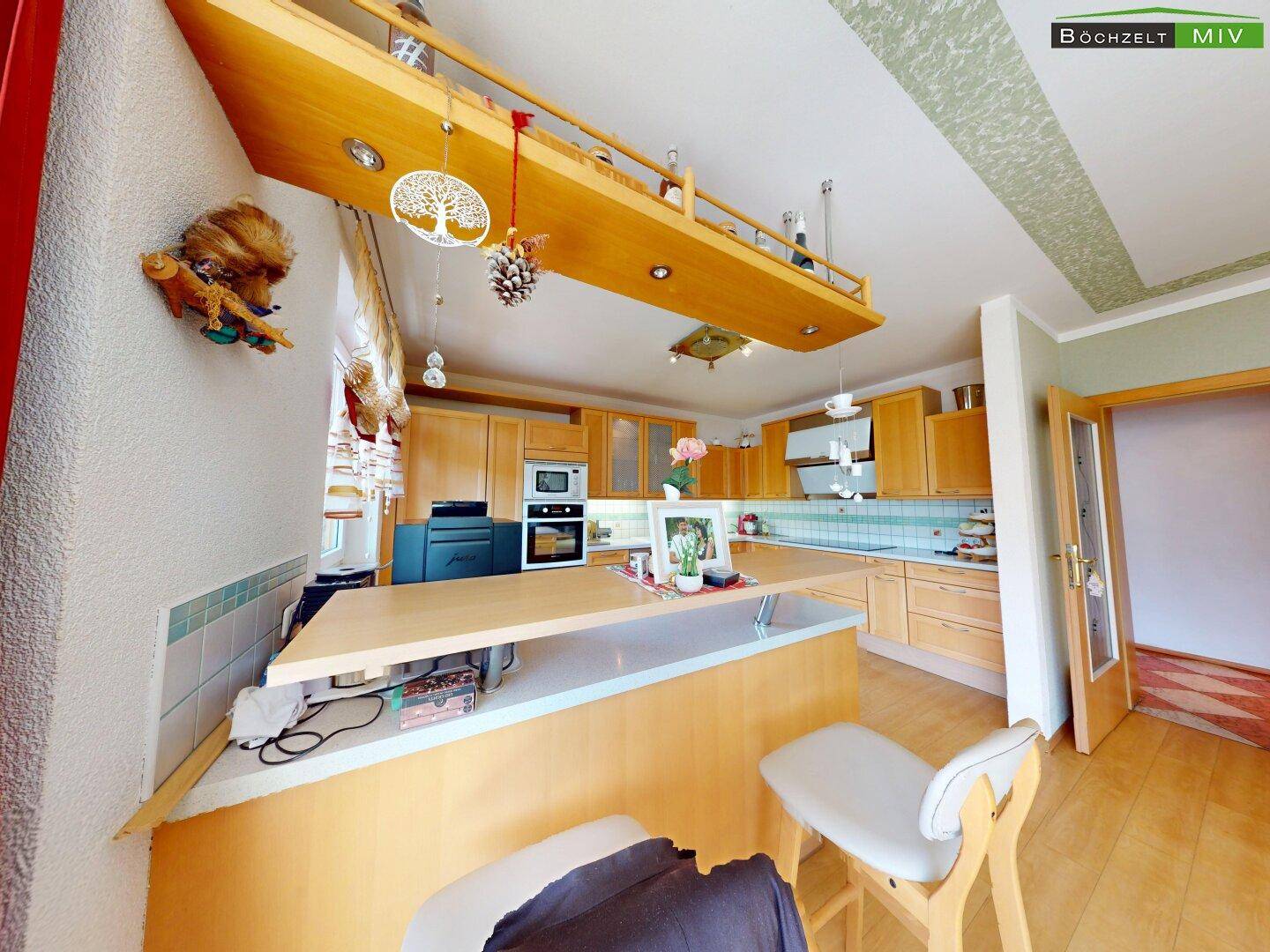Moderne Küche mit Holzschränken, Kücheninsel und integrierten Geräten.