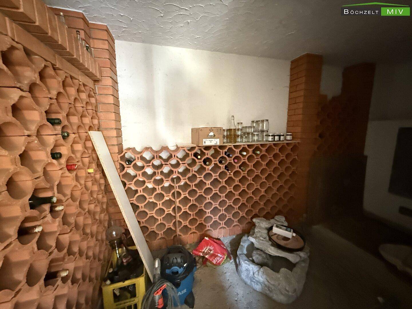 Rustikaler Weinkeller mit Ziegelregalen und Flaschenlagerung, ideal für Weinliebhaber.