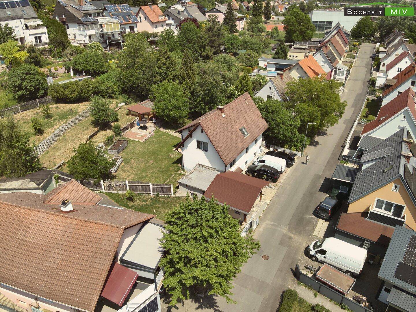Weitwinkel-Luftaufnahme des Hauses mit Carport, Garten und der umliegenden Wohngegend.