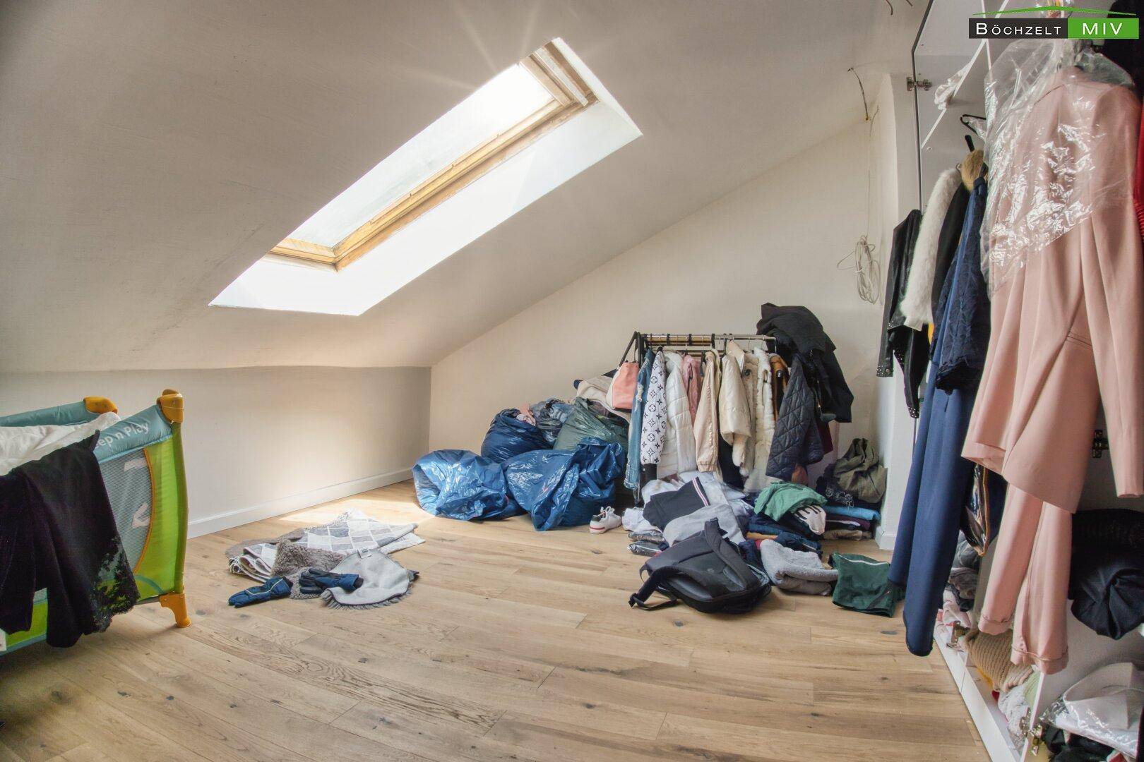 Dachgeschossraum mit Schrägen, Dachfenster und Holzboden, als Abstellraum genutzt.