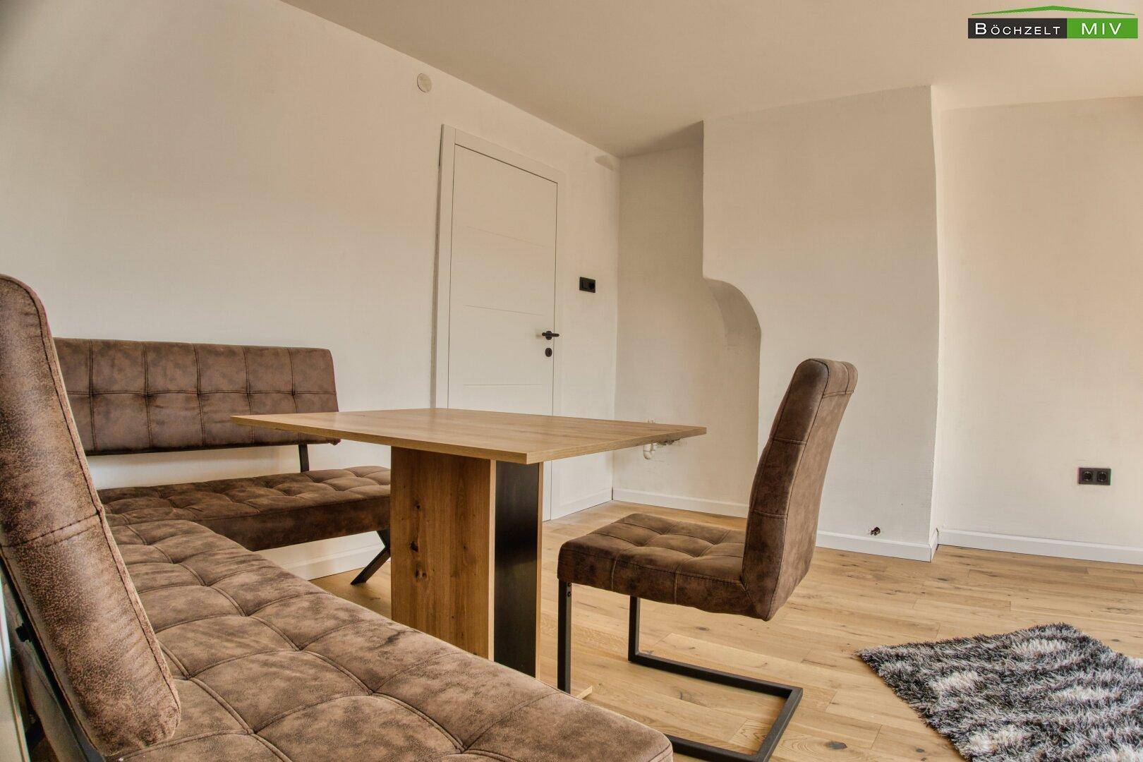 Moderner Essbereich mit Holztisch und gepolsterter Sitzbank, ideal für gesellige Runden.