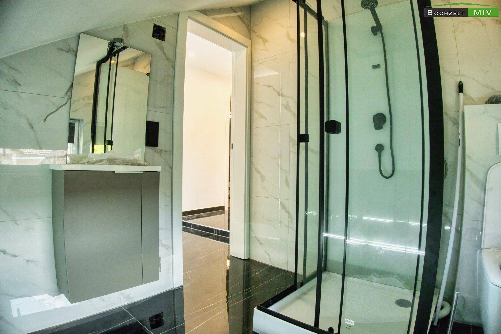 Modernes Badezimmer mit Duschkabine, Waschtisch und Spiegel, in elegantem Design.