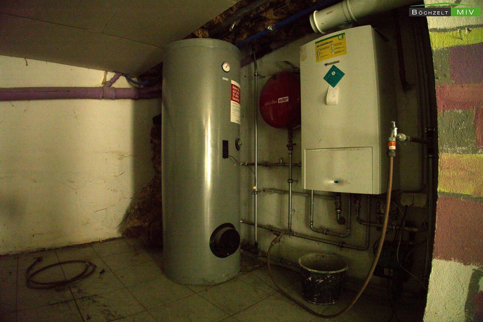 Technikraum im Keller mit Warmwasserspeicher und Heizungsinstallationen.