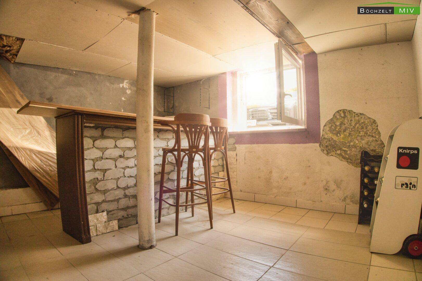 Kellerraum mit Bar, Hockern und Fenster, bietet Potenzial für individuelle Gestaltung.