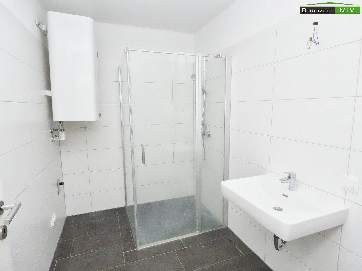 Modernes Badezimmer mit Dusche, Waschbecken und weißen Fliesen, sehr gepflegt.