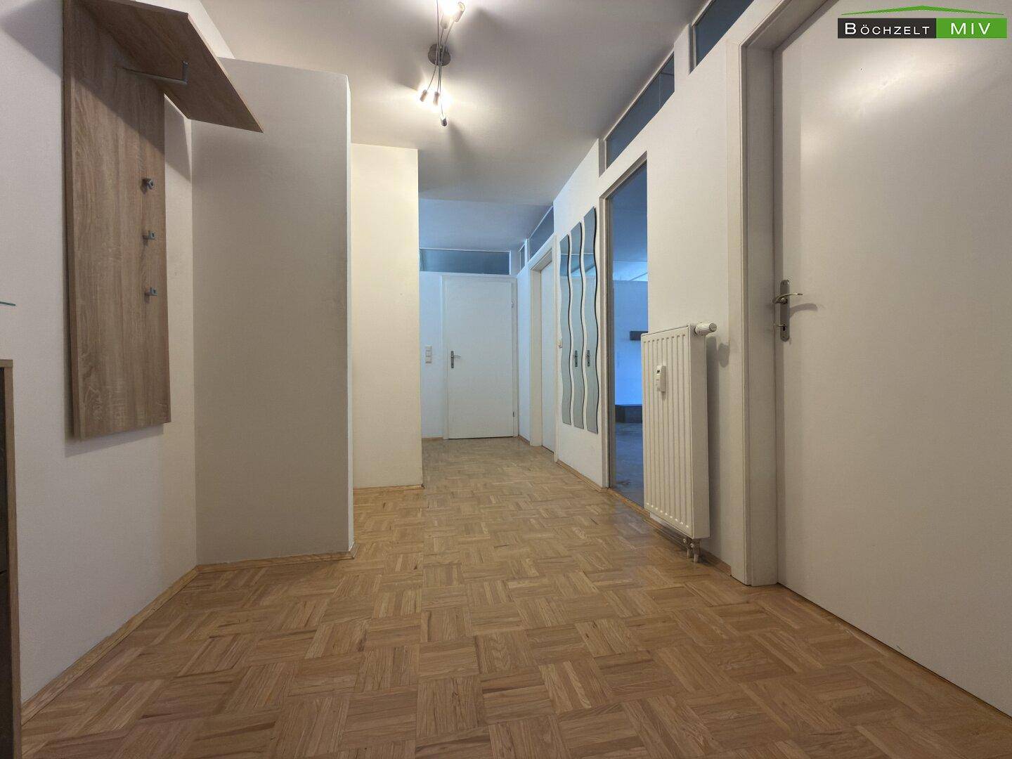 Geräumiger Flur mit Parkettboden und Garderobenbereich.