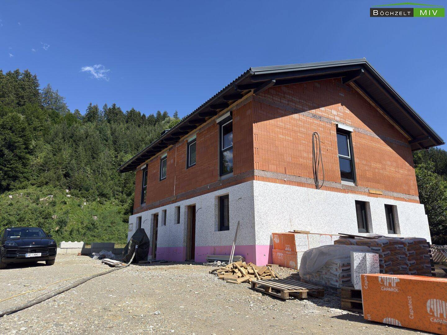 Neubau eines Hauses in Massivbauweise mit Ziegelwänden und beginnender Dämmung in ländlicher Umgebung.