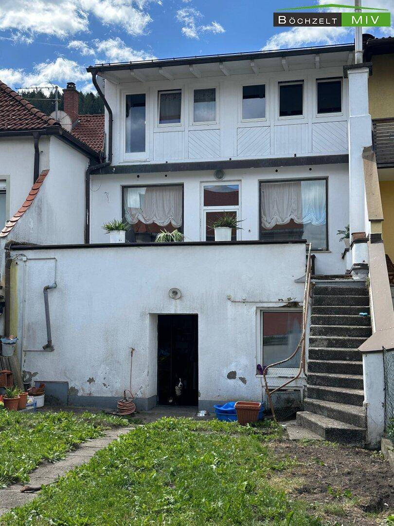 Hinterhof mit Treppe zum oberen Stockwerk und einem kleinen Gartenbereich.