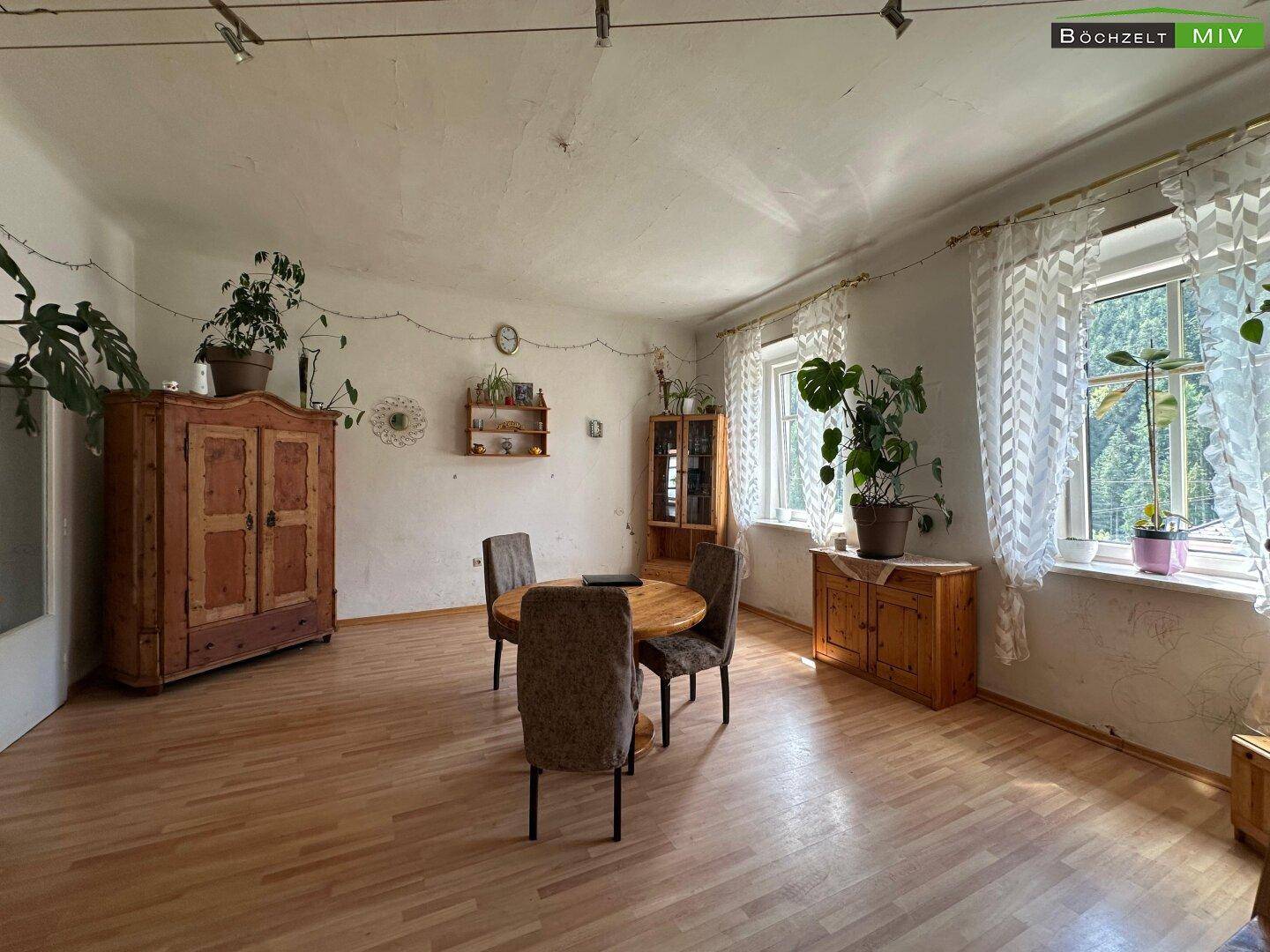 Gemütlicher Essbereich mit traditionellen Holzmöbeln und viel Tageslicht durch die Fenster.