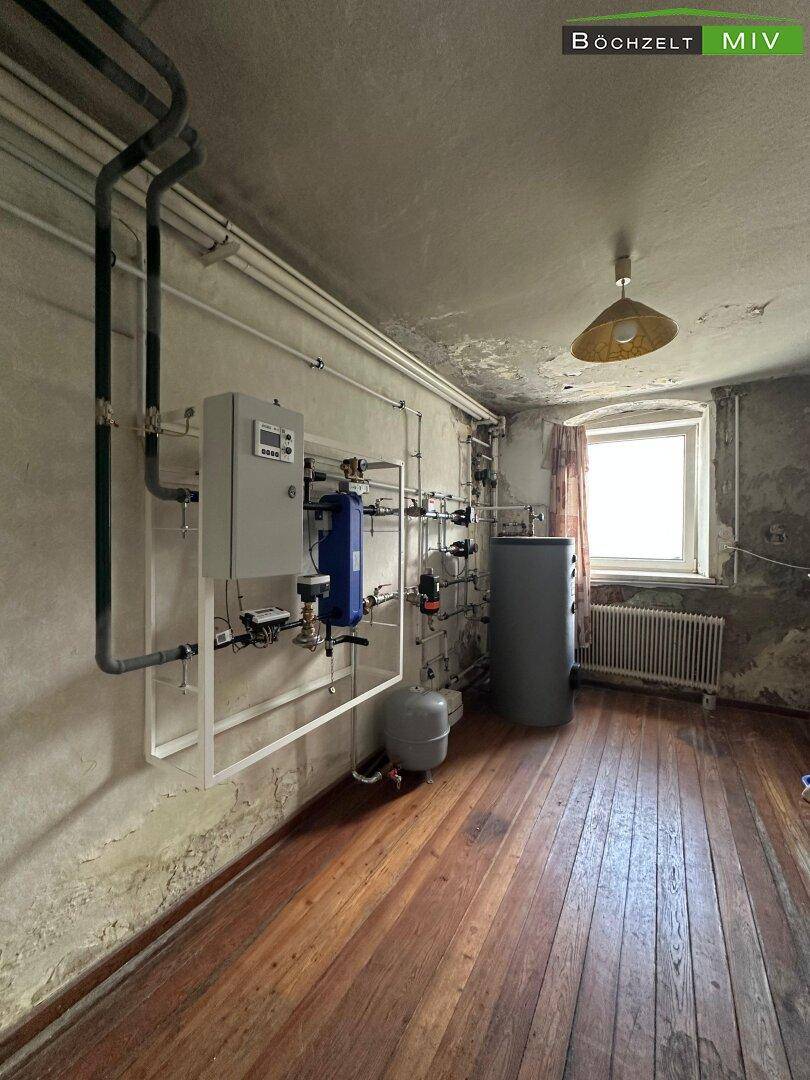 Hauswirtschaftsraum mit Heizungsanlage, Rohren und einem Fenster.