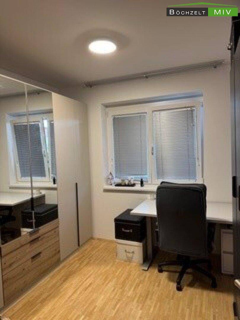 Helles Arbeitszimmer mit Schreibtisch, Bürostuhl und Fenster für produktives Arbeiten.
