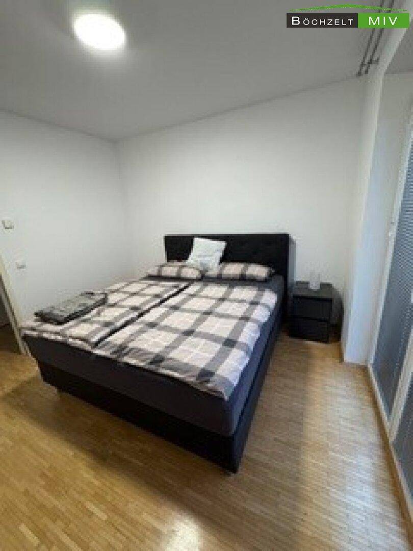 Gemütliches Schlafzimmer mit Doppelbett, Nachttisch und Holzboden für erholsame Nächte.