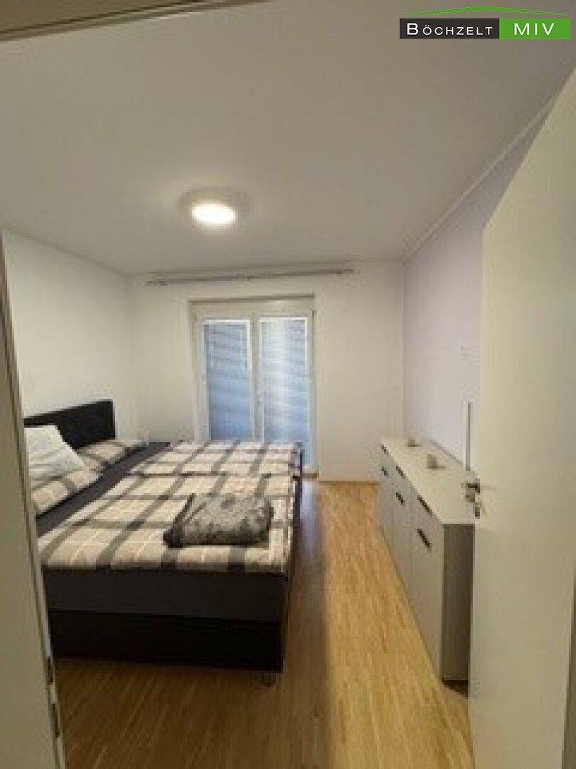 Schlafzimmer mit Doppelbett, Kommode und Fenster mit Jalousien für Privatsphäre.