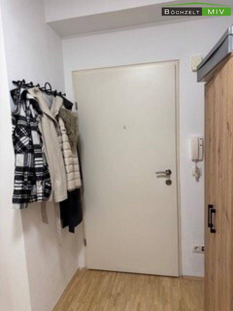 Eingangstür von innen mit praktischer Wandgarderobe und Gegensprechanlage.