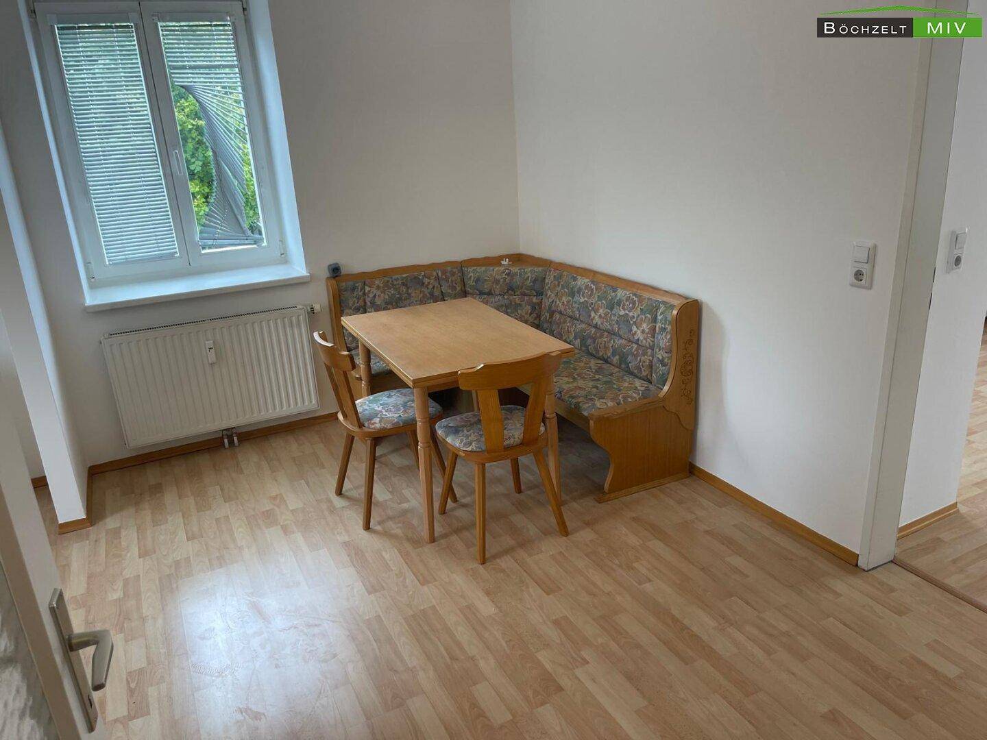 Gemütlicher Essbereich mit Eckbank und Holztisch, ideal für Mahlzeiten am Fenster.