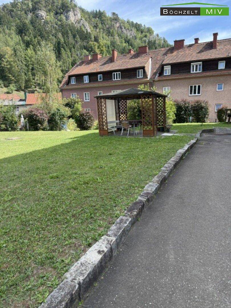 Gemeinschaftlicher Gartenbereich mit Rasenfläche und einem Holzpavillon.