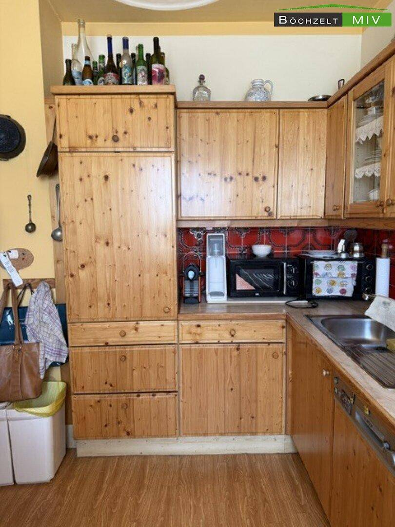 Rustikale Holzküche mit integriertem Kühlschrank und Mikrowelle, sowie Stauraum.