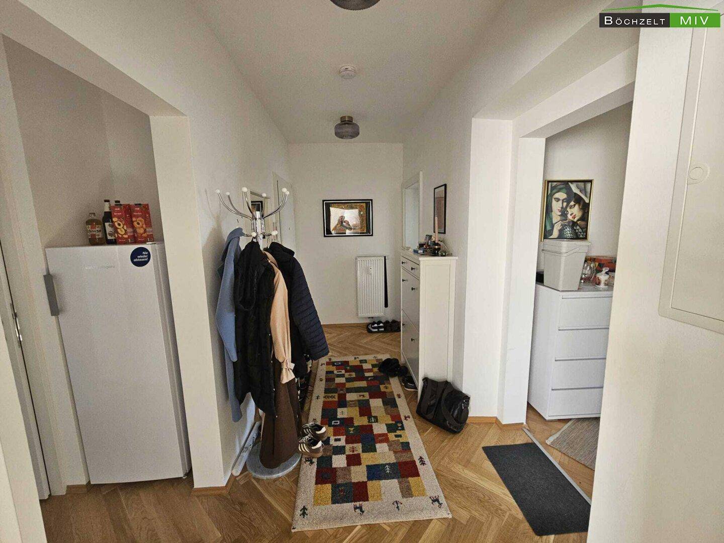 Geräumiger Flur mit Garderobe, Kommoden und Fischgrätparkettboden.