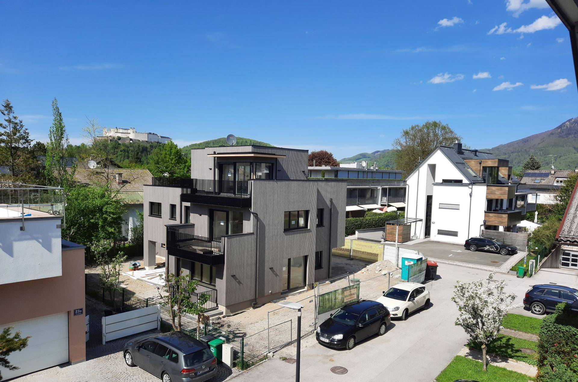 Neubauwohnungen mit moderner Architektur und Flachdächern in einer Wohngegend.