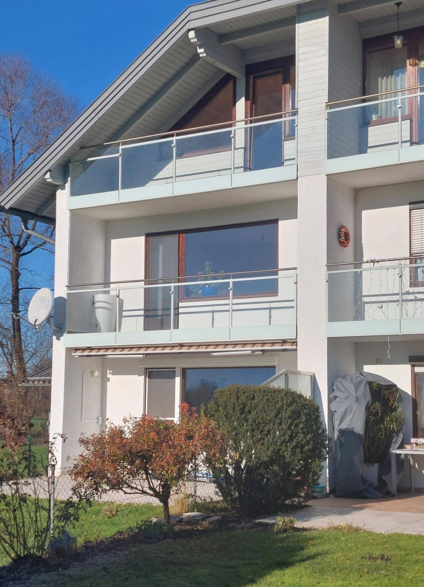 Fassade eines Wohnhauses mit mehreren Balkonen und Glasgeländern.