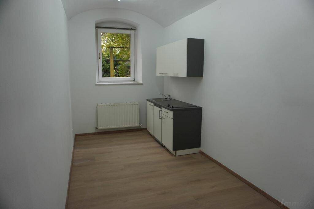 Kleine Küchenzeile in einem hellen Raum mit gewölbter Decke und Fenster, praktisch und funktional.