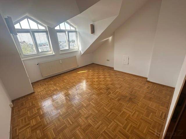 Geräumiges Schlafzimmer im Dachgeschoss mit Parkettboden und großen Fenstern.