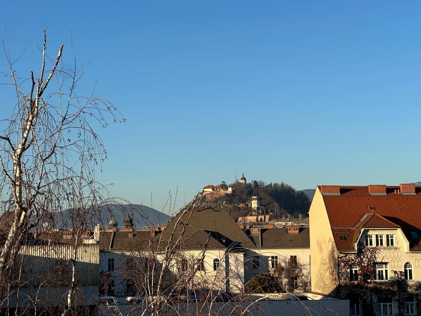 Panoramablick über die Stadt mit historischen Gebäuden und einer Festung auf dem Hügel.