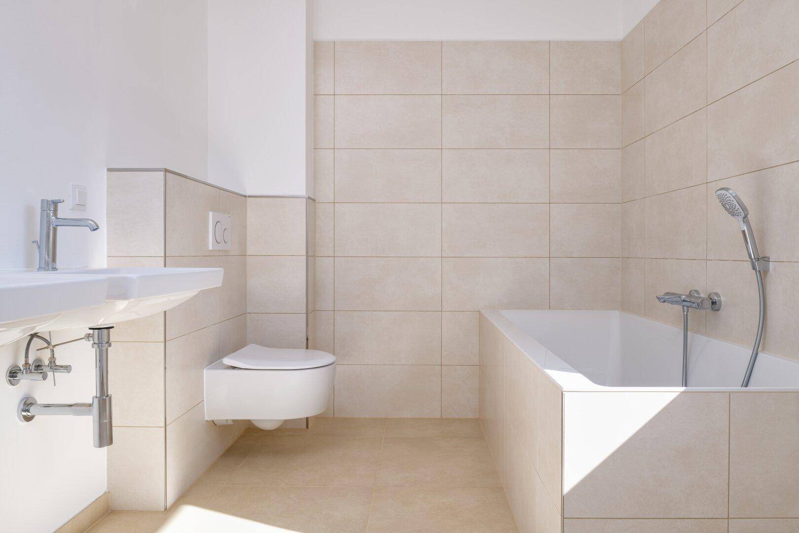 Modernes Badezimmer mit Badewanne, wandhängendem WC und hellem Fliesenboden.