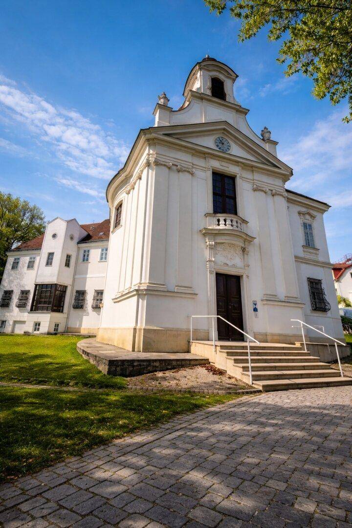 Eindrucksvolles, weißes Kirchengebäude mit barocker Architektur und einer breiten Freitreppe.