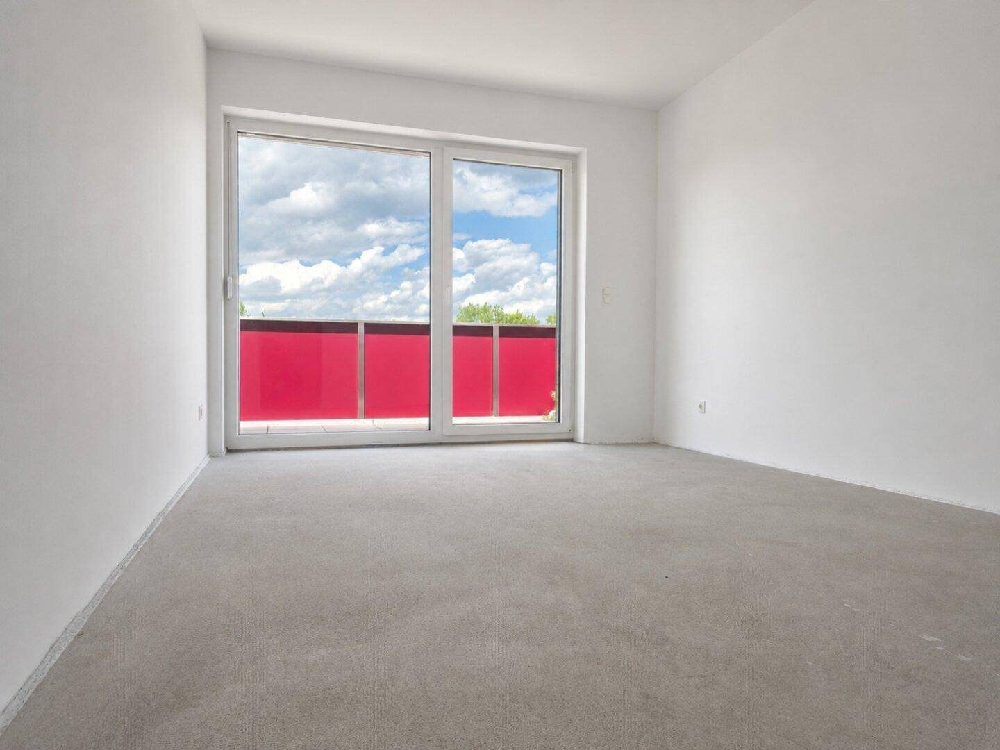 Unmöbliertes Schlafzimmer mit großen Fenstern und Schiebetür zum Balkon, bereit zur Einrichtung.